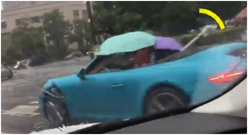 敞篷跑车打伞前行